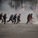 Demonstrators run across a street during an anti-government protest in La Paz, Bolivia, Monday, May 18, 2026. (AP Photo/Freddy Barragan)