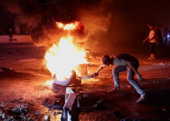 Halep ile Türkiye arasındaki otoyolda bir eylemci, Suriye'deki yakıt fiyatı artışını protesto etmek amacıyla lastik yakıyor; Halep, Suriye, 13 Eylül 2026. REUTERS/Mahmoud Hassano